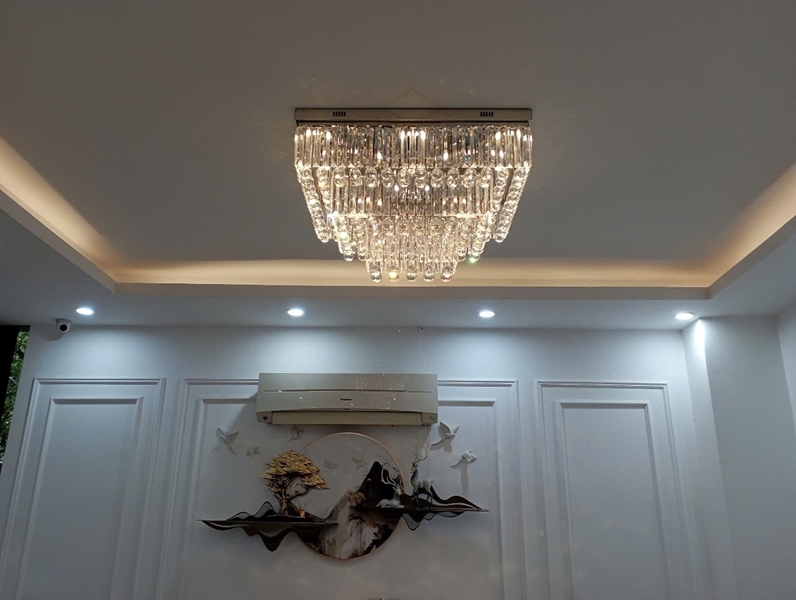 Đèn chùm pha lê thả thông minh PL024 gồm 3 tầng thanh tam giác trắng, hạt D40 đèn led COB dimer 3 màu có điều khiển xa, mâm inox gương trắng hình chữ nhật, KT(mm): 1500 x 600 x 450